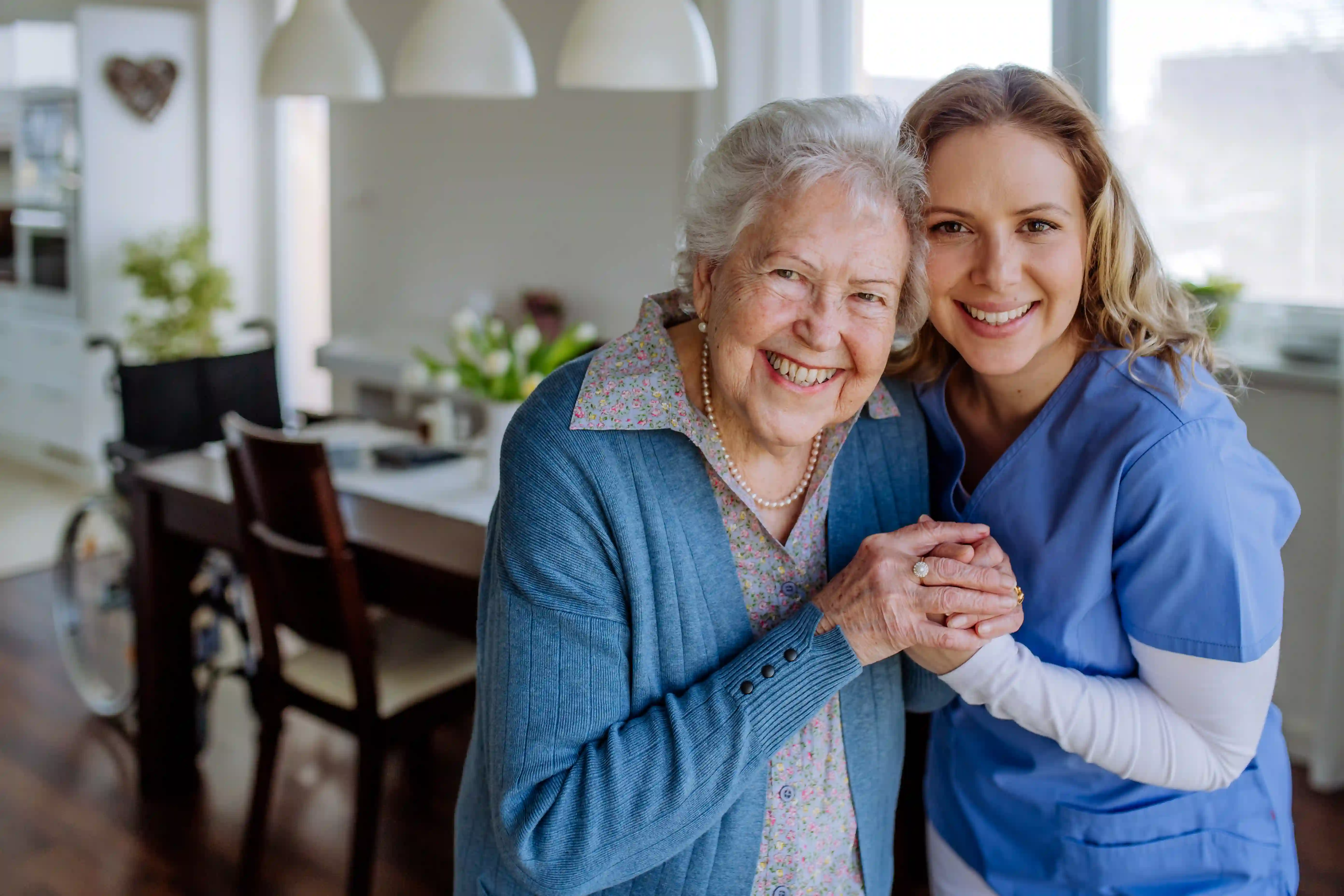 Caregiver and senior resident smiling together in a group home